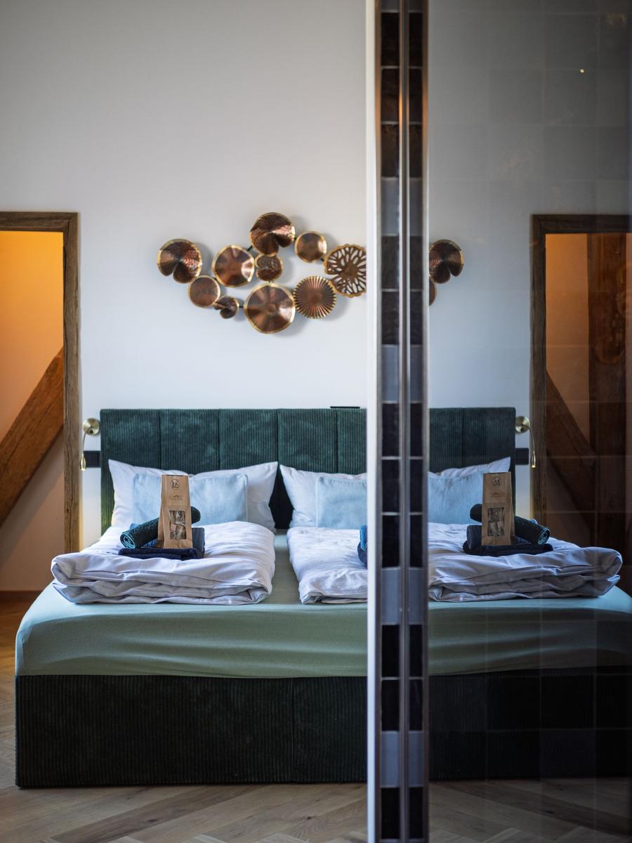 Doppelbett mit grünem Kopfteil und Wanddekoration