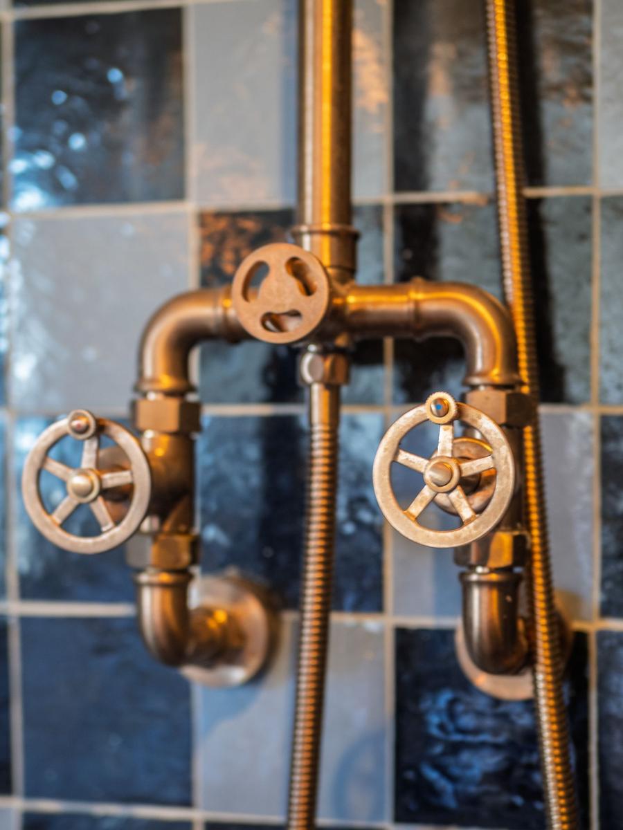 Antik-ähnliche Duscharmaturen an einer Fliesenwand