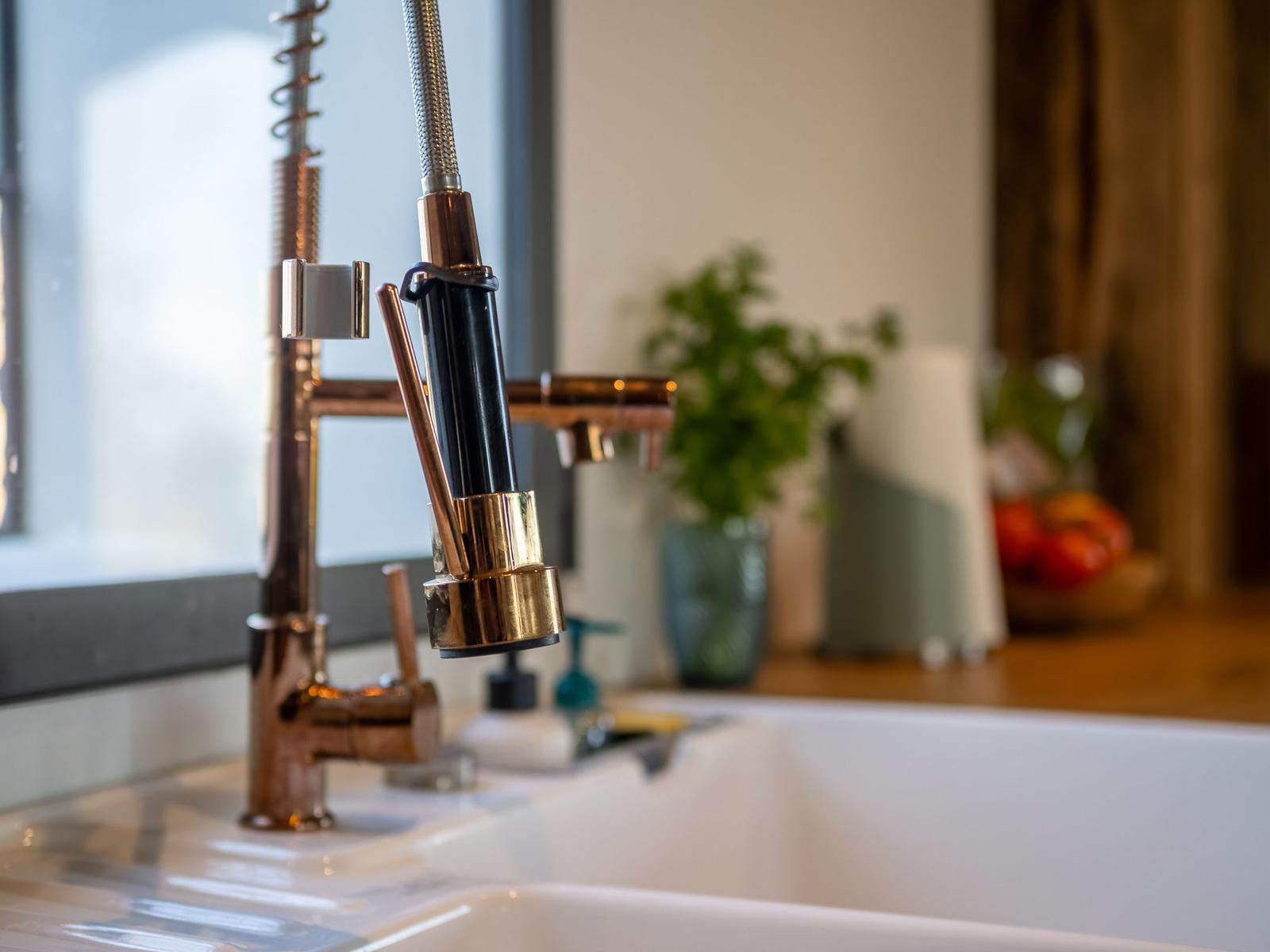 Küchenarmatur mit Schlauchhahn über weißem Spülbecken