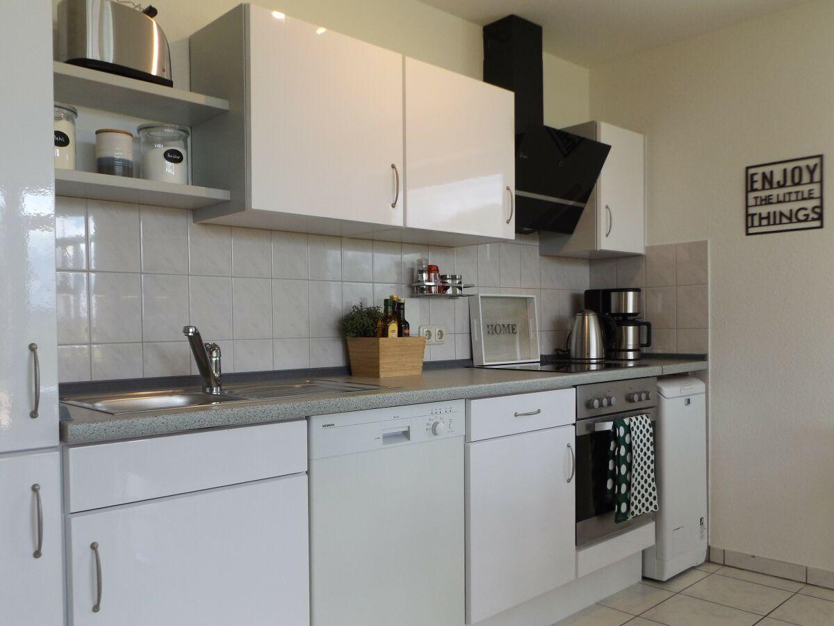 Kitchen with white cabinets, sink, dishwasher, and stove.