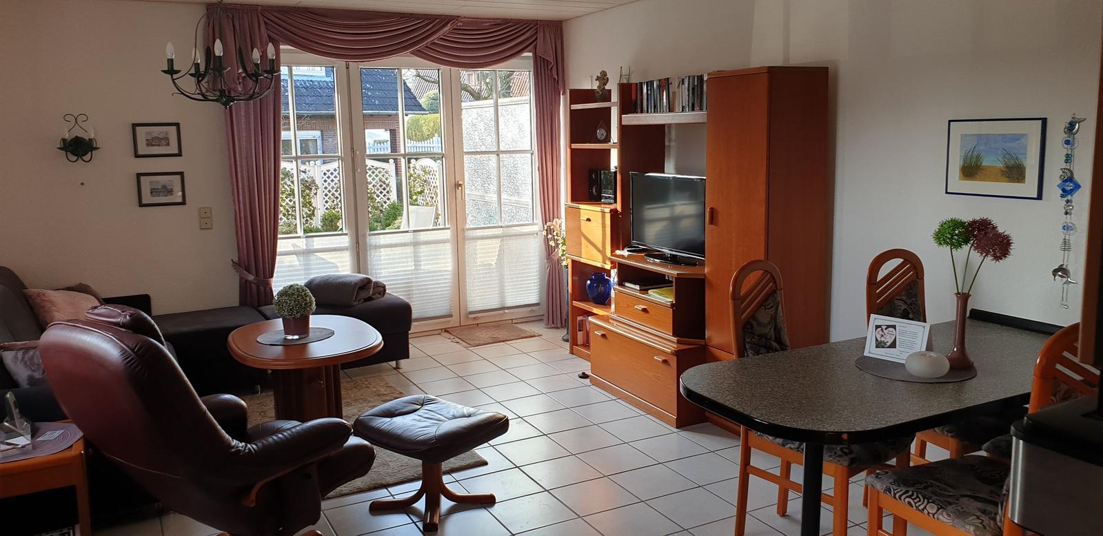 Wohn- und Essbereich mit Fernseher, Esstisch und Sitzgelegenheiten.