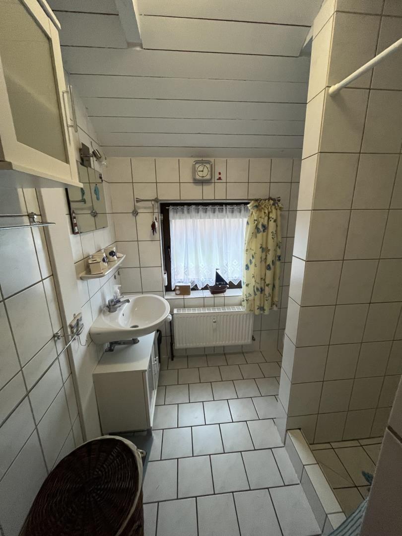 Bathroom with sink, window, and shower area.