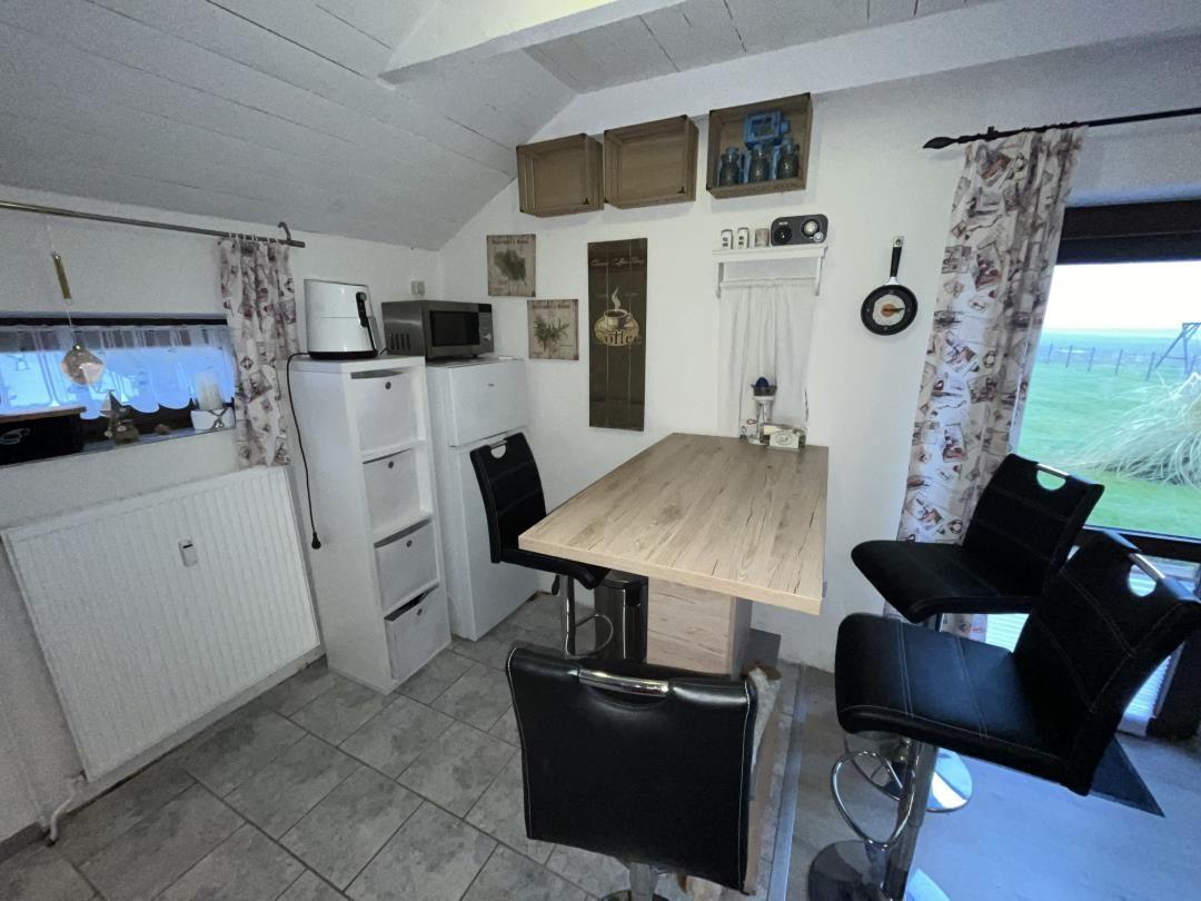 Kitchen with table, chairs, and view of green field.