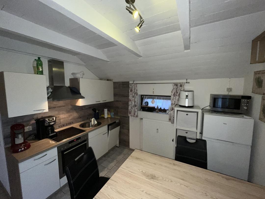 Kitchen with worktop, sink, stove, and cabinets.