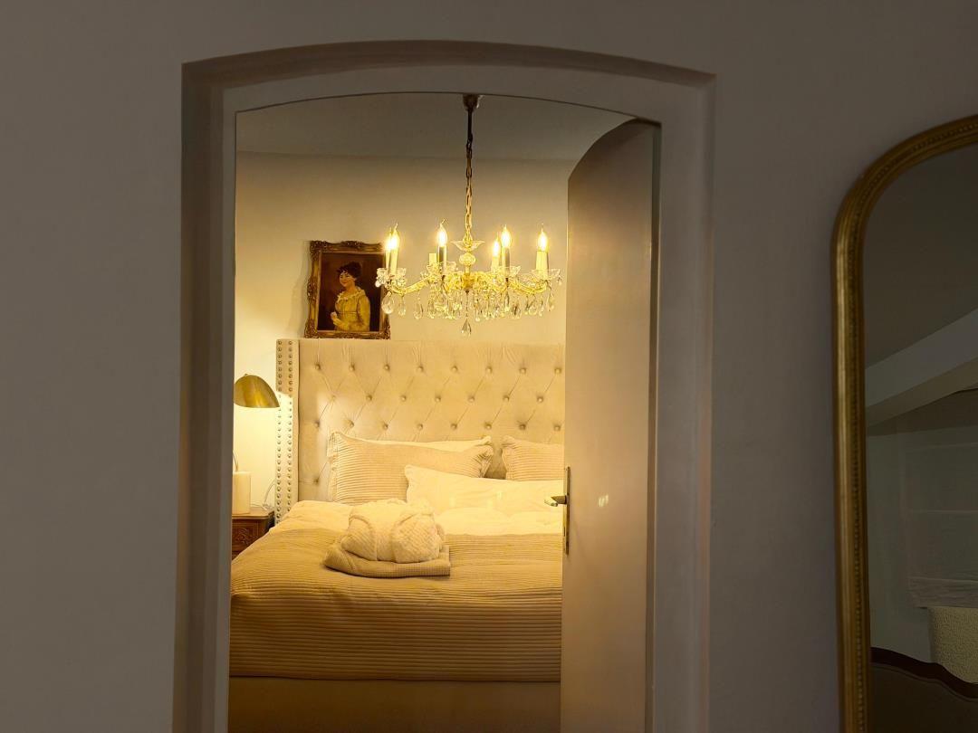 Bedroom with bed, chandelier, and mirror