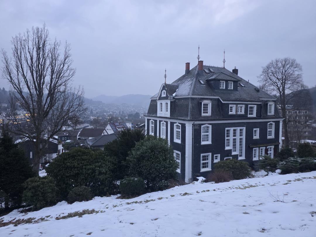Black house with white windows on snowy slope