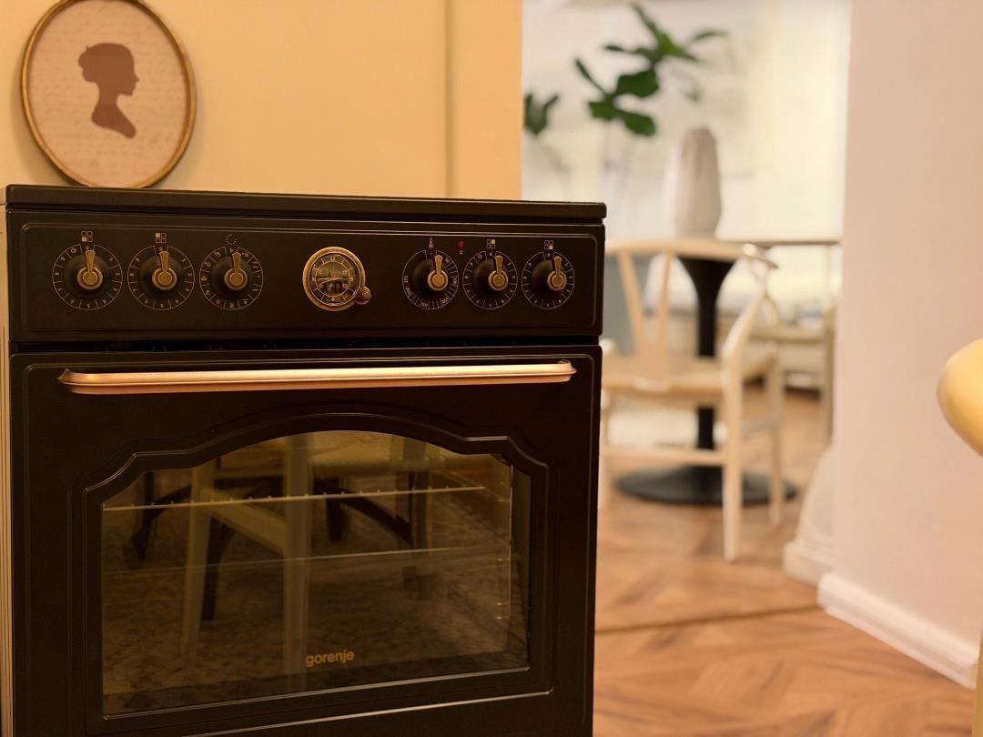 Black Gorenje stove with knobs and glass door in kitchen area