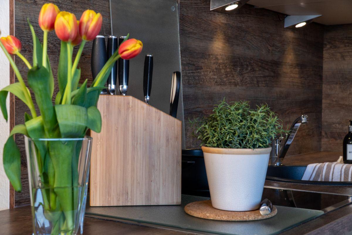 Küchenzeile mit Tulpen, Messerblock und Pflanze auf Arbeitsfläche
