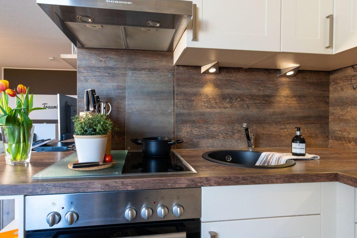 Küche mit Holzoptik, Herd, Spüle und Küchenzeile