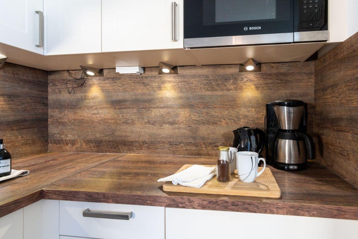 Küche mit Holzoberfläche, Mikrowelle und Kaffeemaschine.