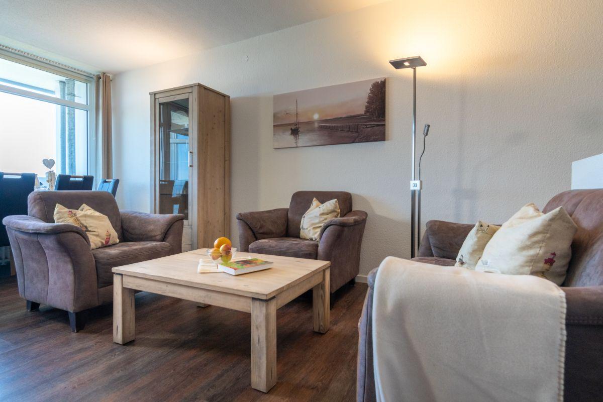 Wohnzimmer mit Sitzgruppe, Tisch und Wandbild.