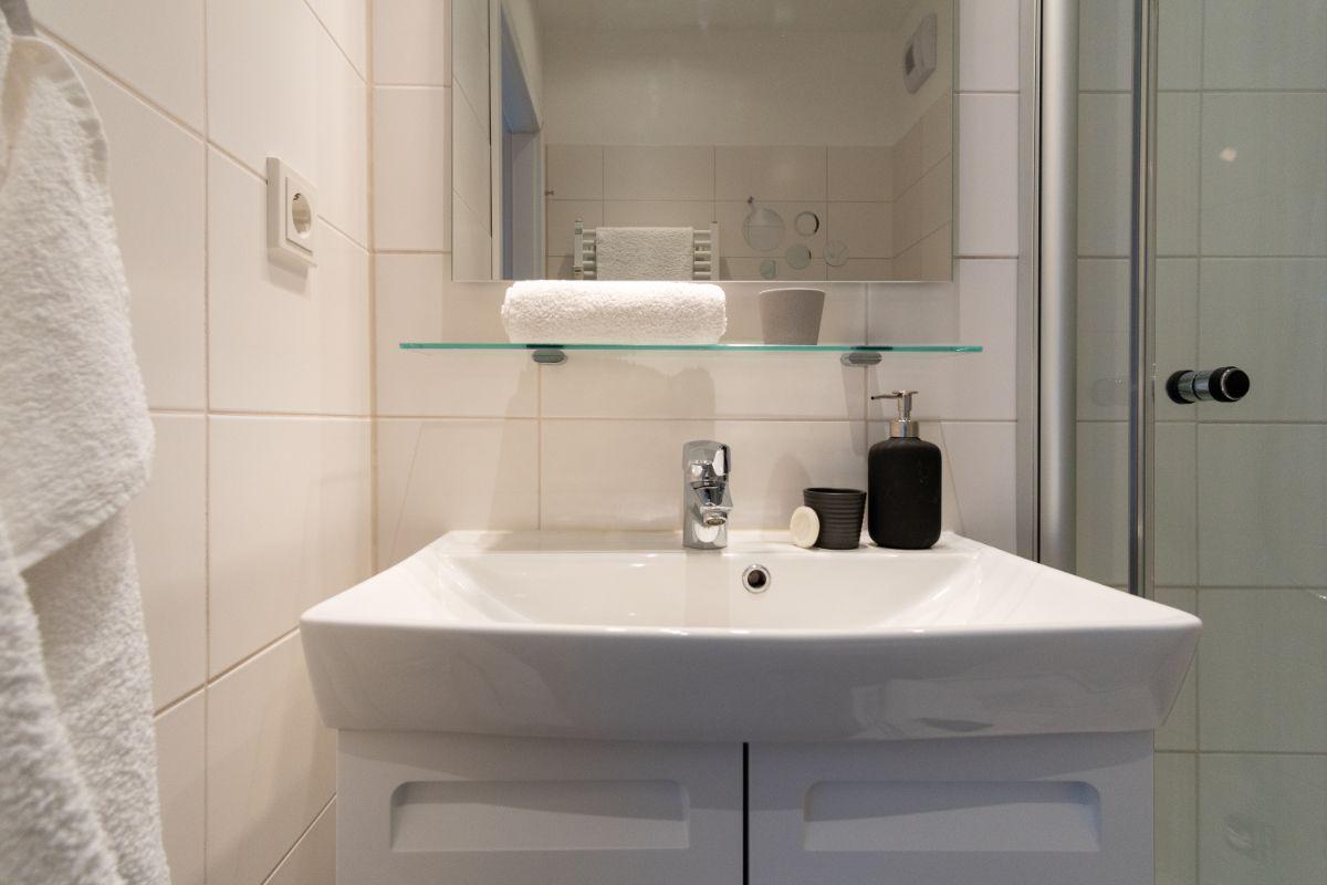 Bad mit Waschbecken, Spiegel und Dusche