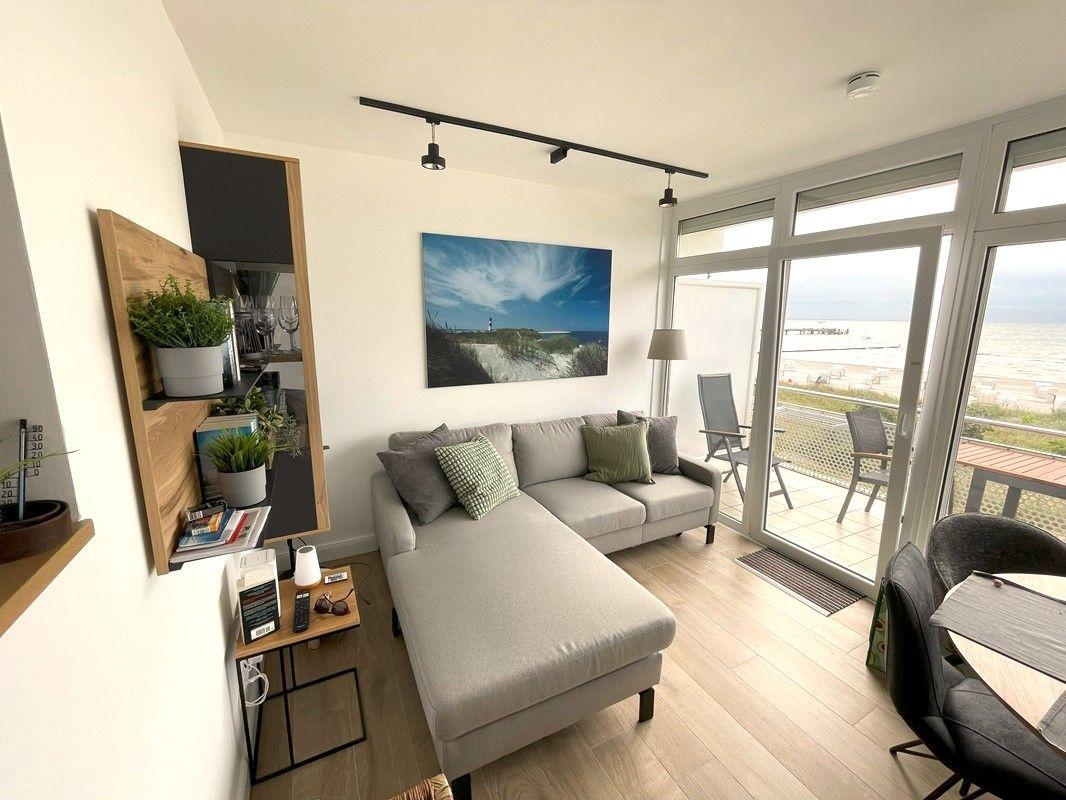 Wohnzimmer mit Sofa, Blick auf Strand und Terrasse.