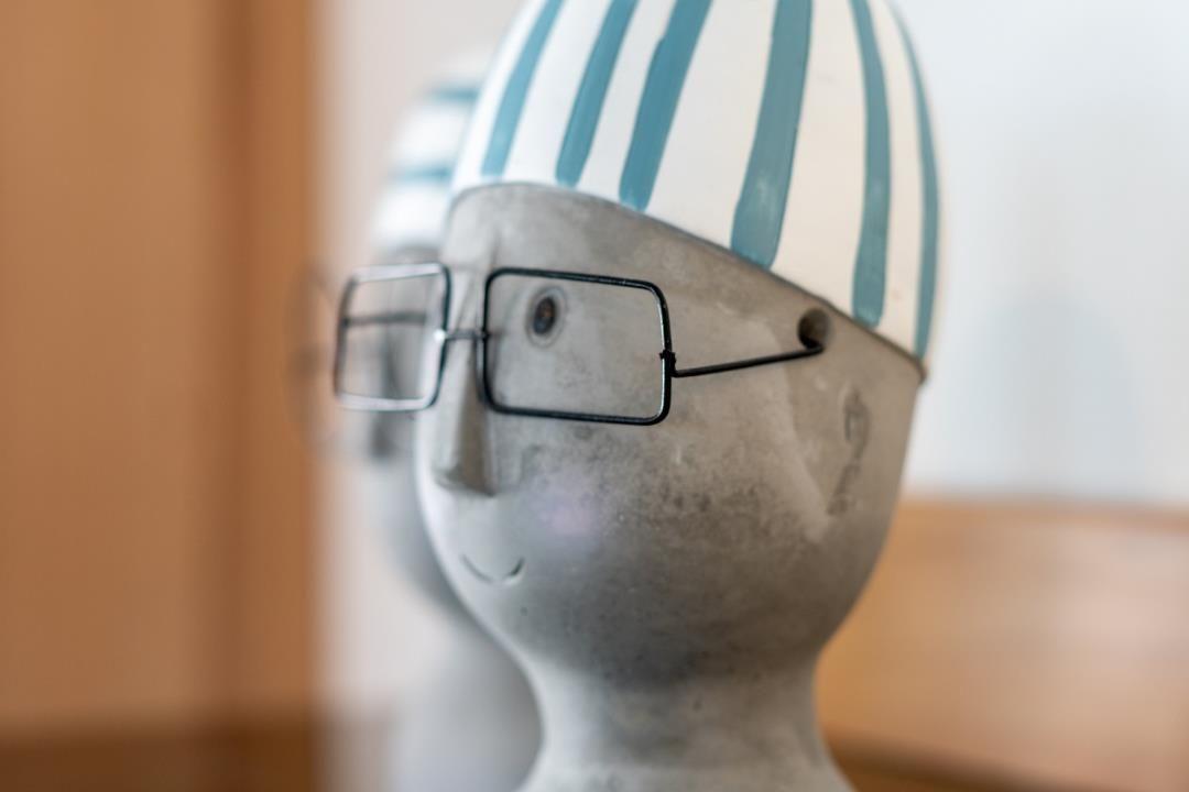 Ein dekorativer Kopf mit Brille und gestreifter Mütze.