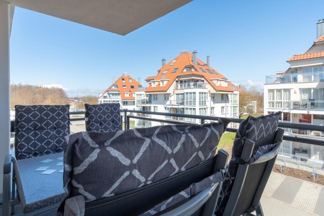 Terrasse mit Sitzgelegenheiten und Blick auf Wohnhäuser.