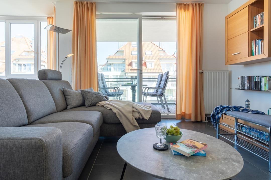 Wohnzimmer mit Sofa, Couchtisch und Balkonansicht