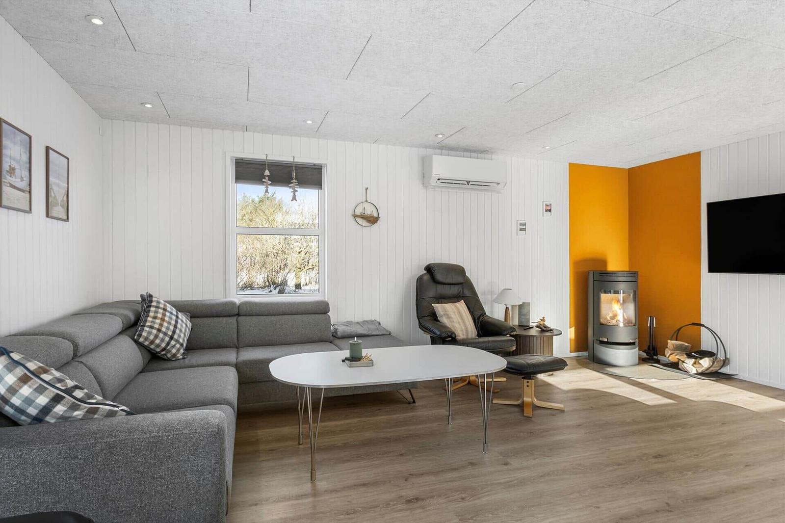Living room with gray sofa, fireplace, and TV on the wall.
