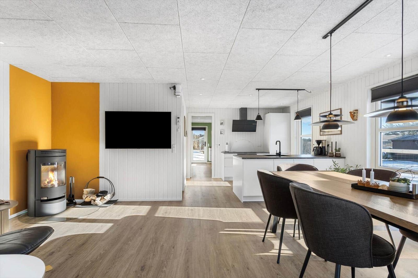 Living area with fireplace, TV, and dining area with table and chairs.