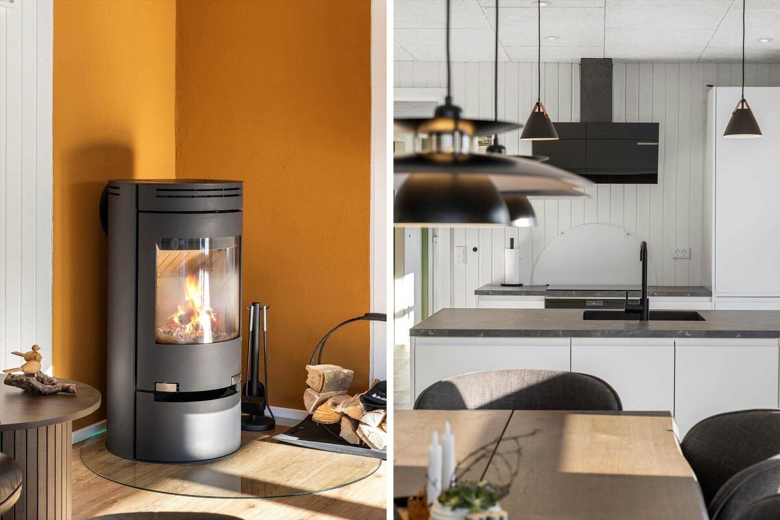 Wood stove beside stacked logs, modern kitchen with countertop and pendant lights.