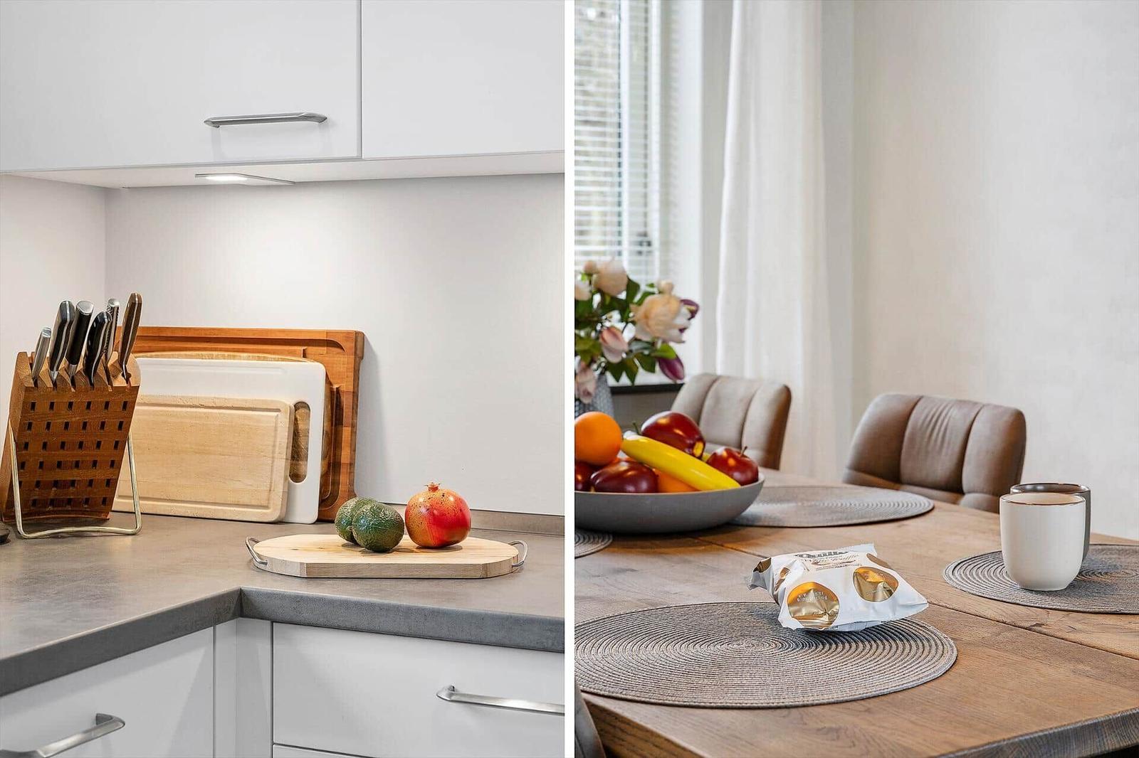 Kitchen with knife block and fruit. Dining area with table, chairs, and fruit bowl.