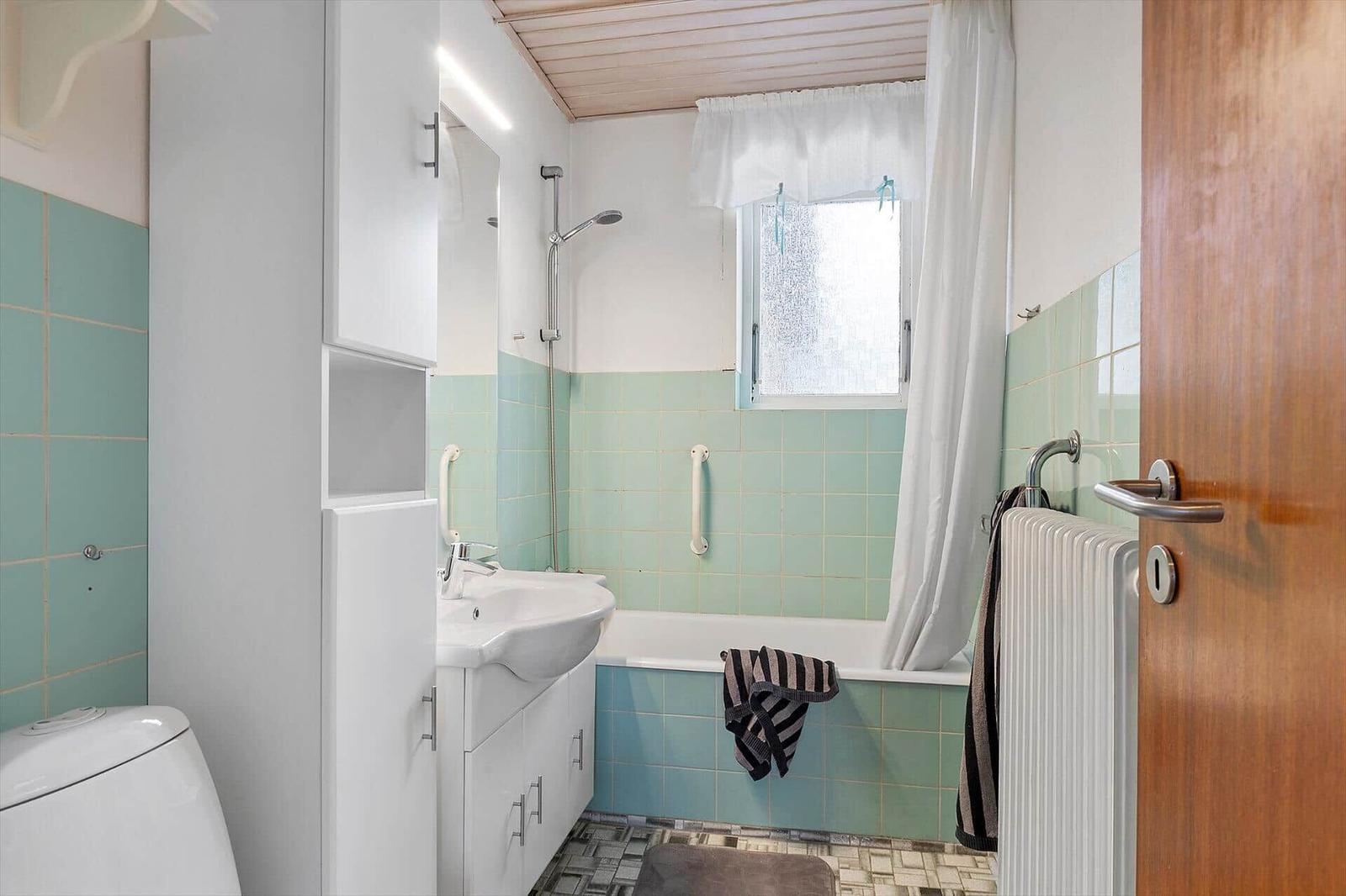 Bathroom with bathtub, shower, sink, and toilet.