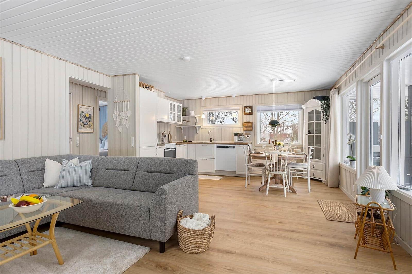Living and dining area with kitchen, sofa, and wooden floor.