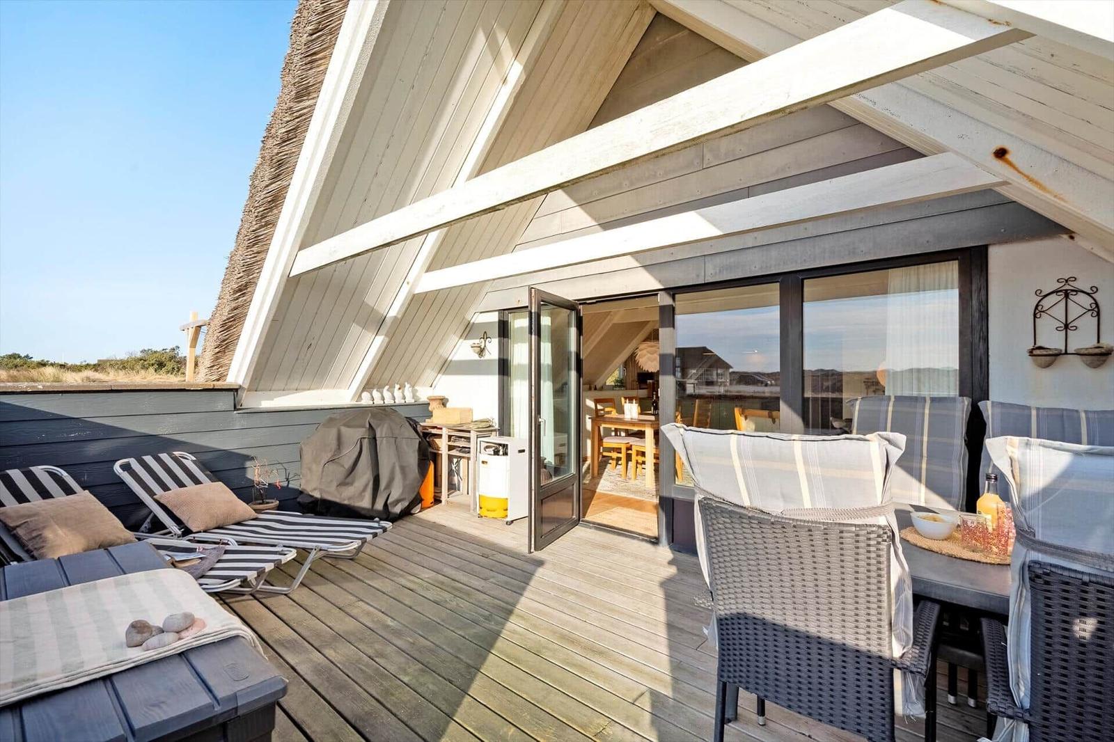 Terrasse mit Sitzgelegenheiten und Blick ins Haus