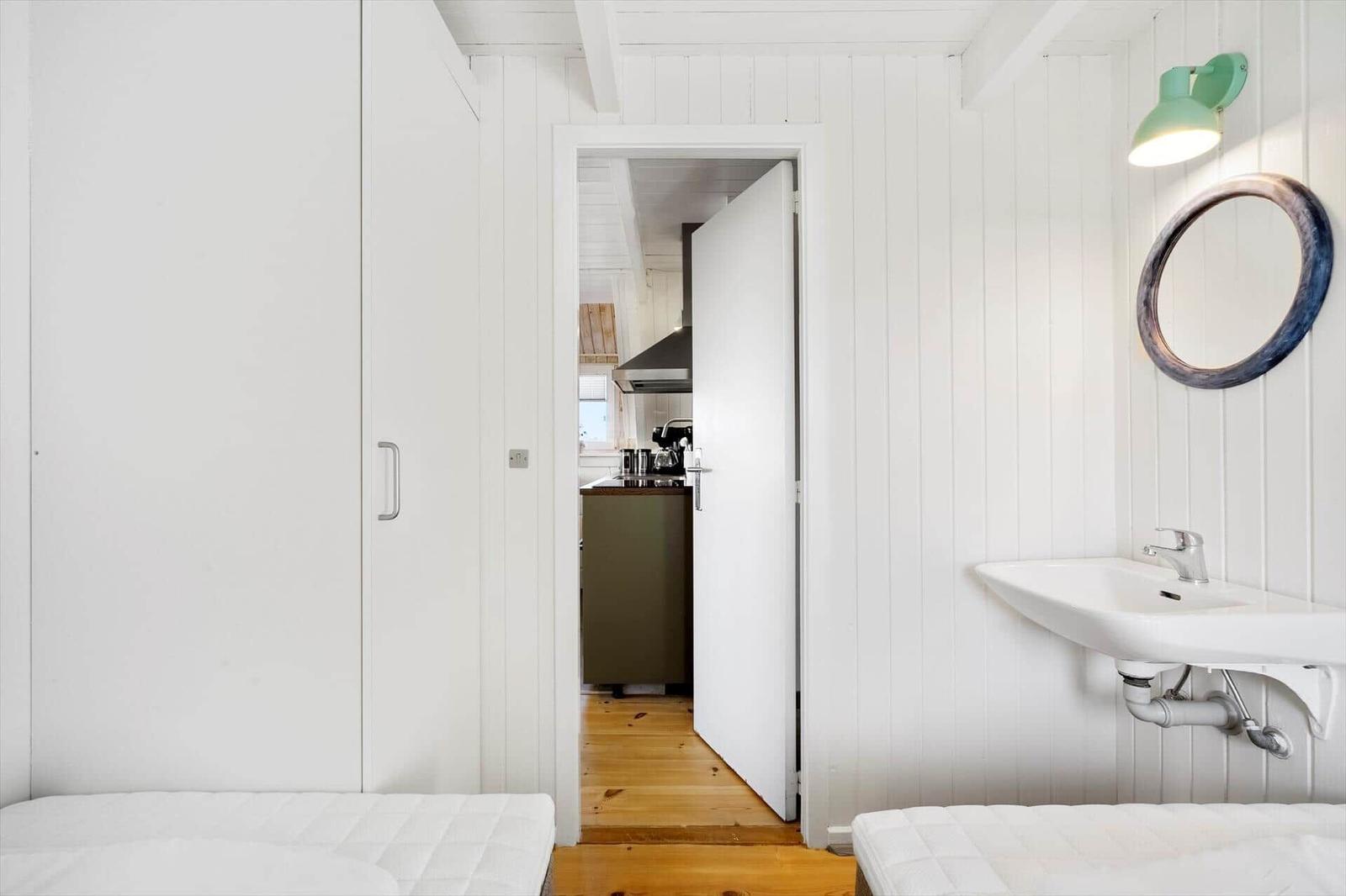 Schlafzimmer mit Doppelbett, Spiegelschrank und Waschbecken