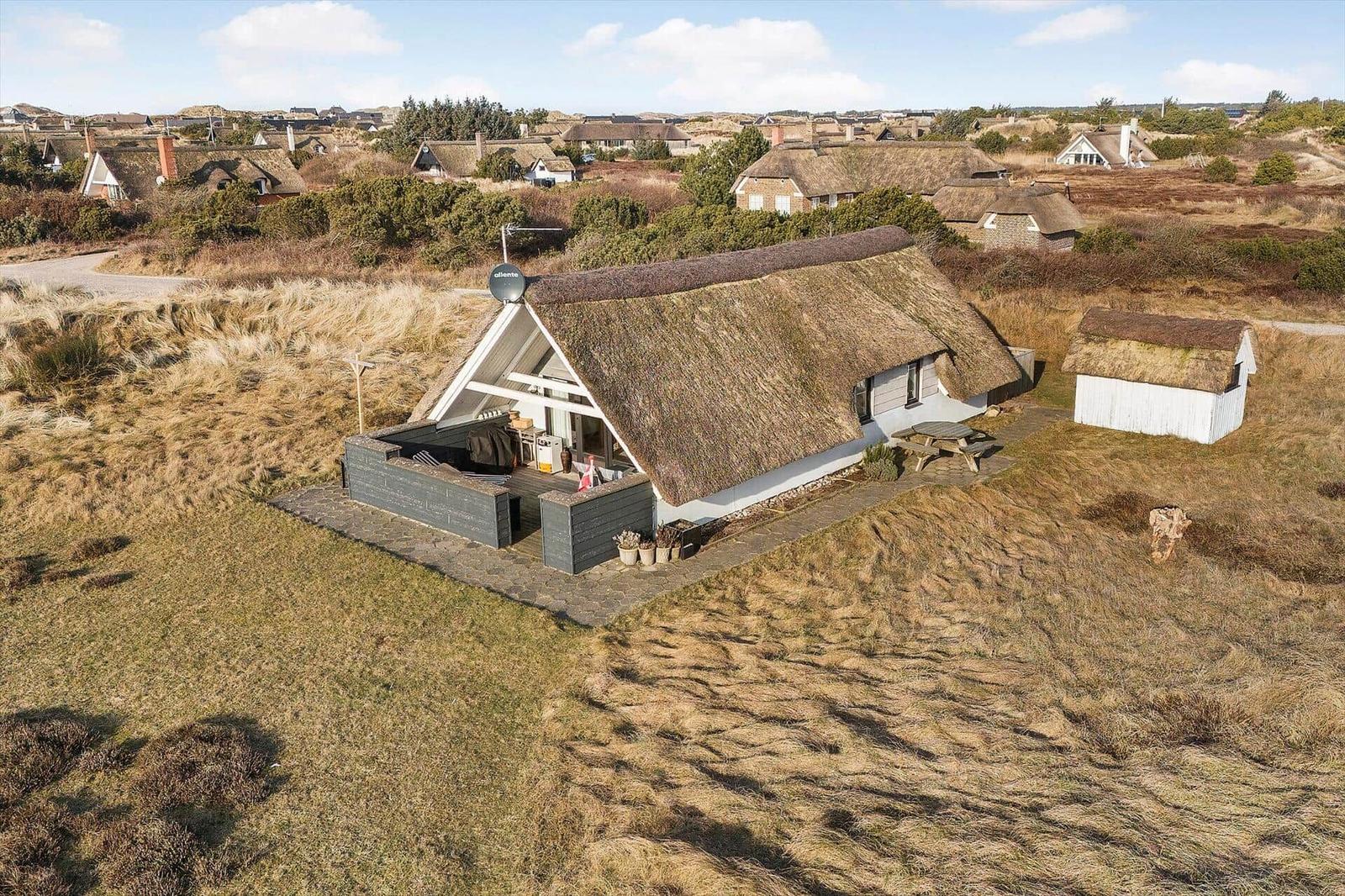 Haus mit Strohdach, Terrasse und Garten in ländlicher Umgebung
