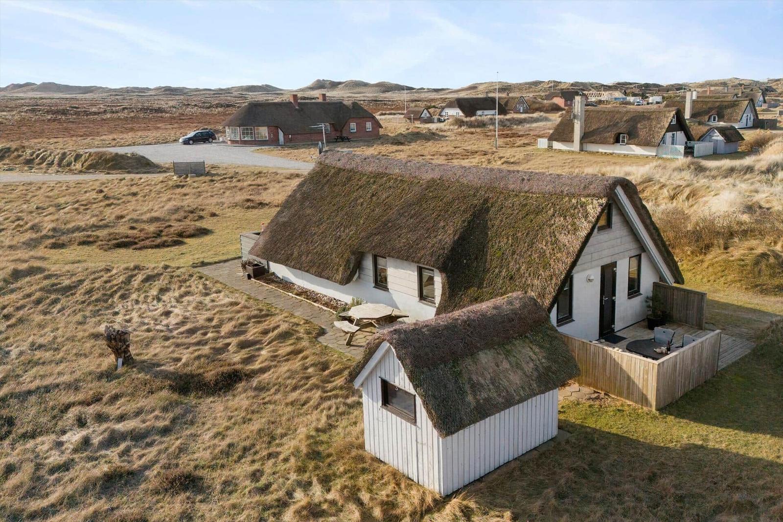 Haus mit Grashütten-Dach in ländlicher Umgebung