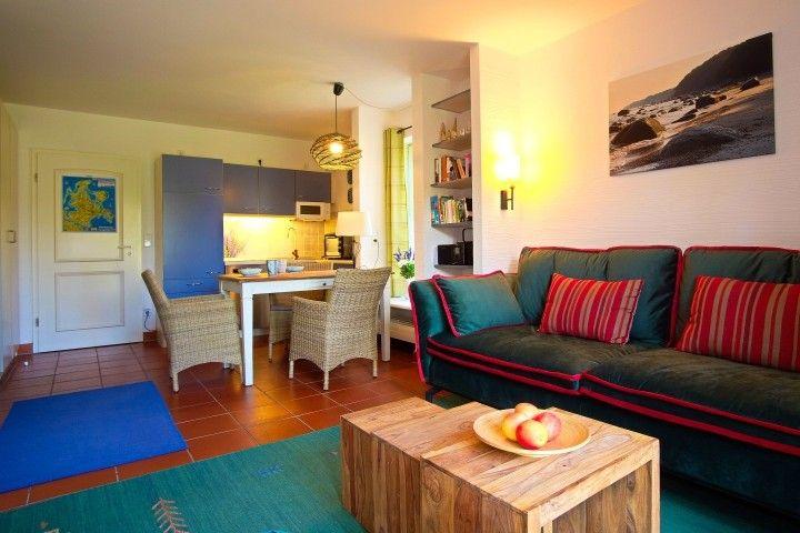 Wohnzimmer mit Sofa, Couchtisch und Küchenbereich im Hintergrund.