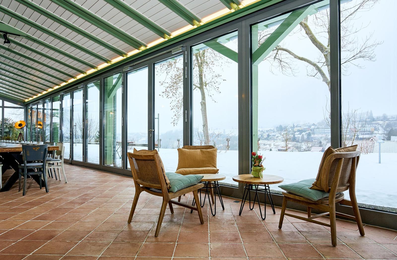 Terrasse mit Sitzgruppe und Blick auf verschneite Landschaft