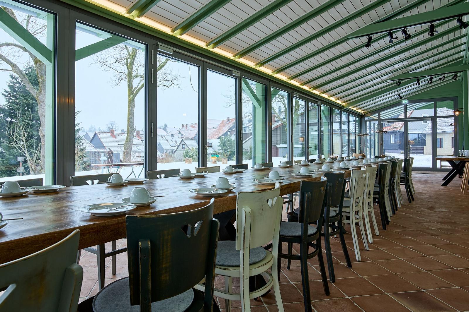 Langes Holztablett mit Stühlen und Blick auf Außenbereich