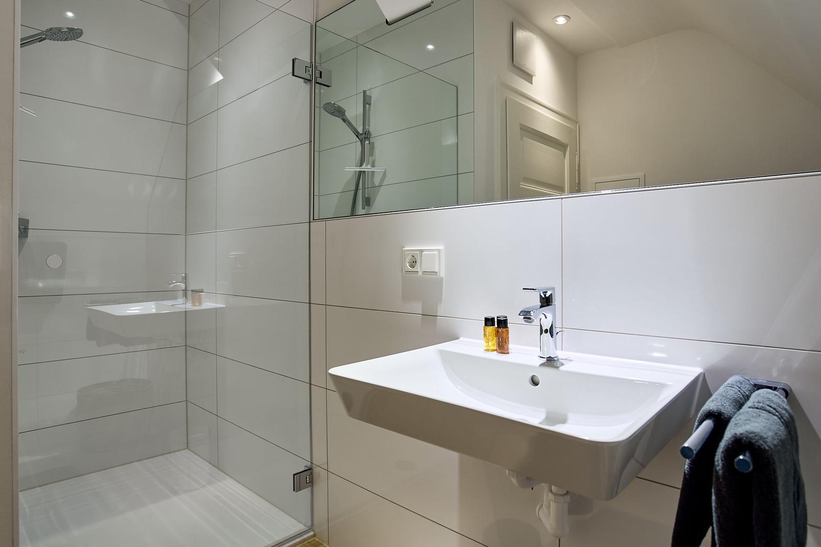 Bad mit Dusche, Waschbecken und Spiegel