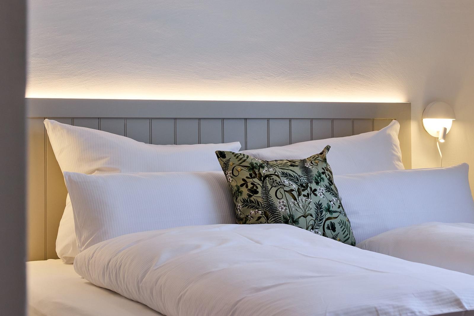 Bettkopfteil mit LED-Beleuchtung und Kissen.