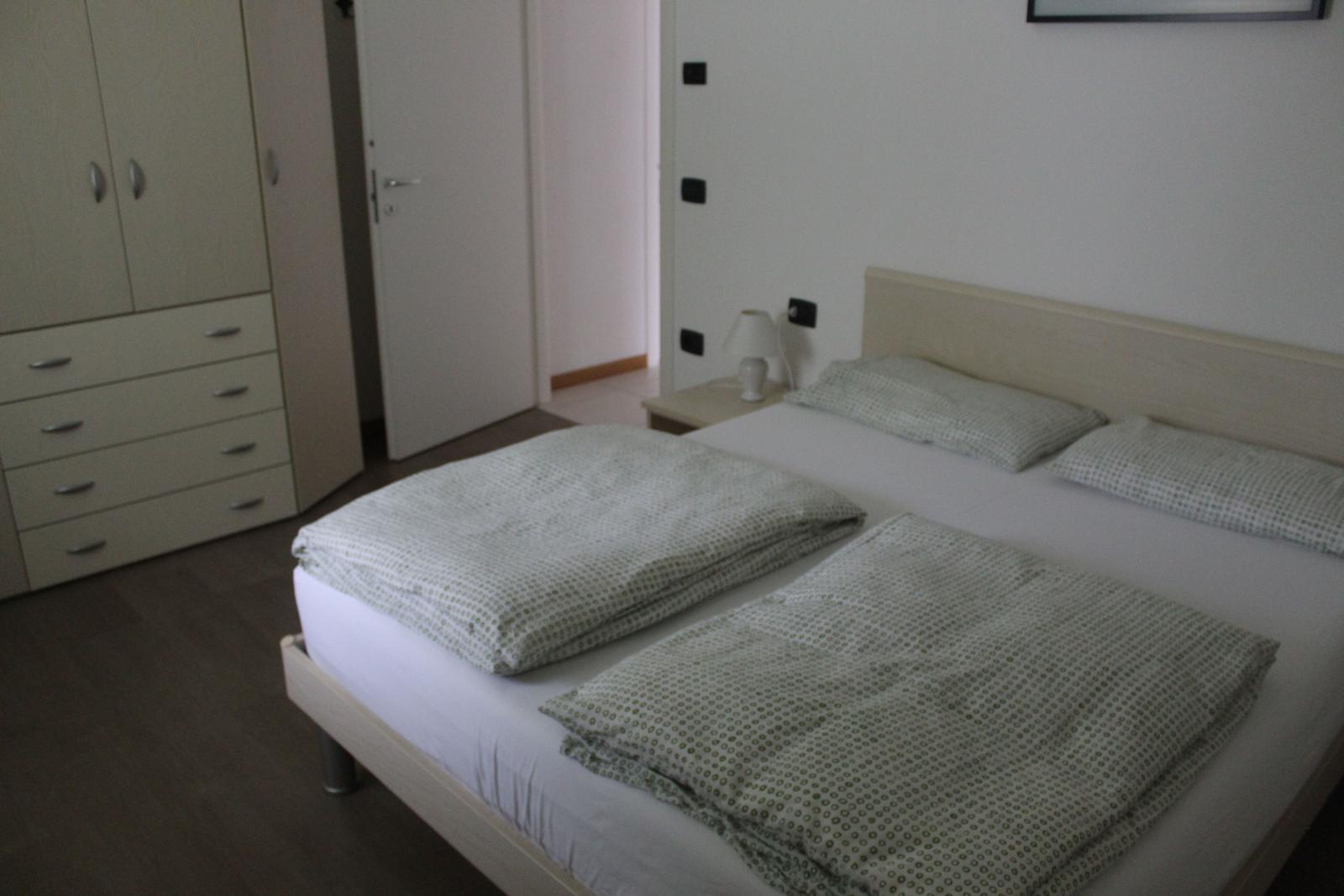 Schlafzimmer mit Doppelbett, Nachttisch und Kleiderschrank.