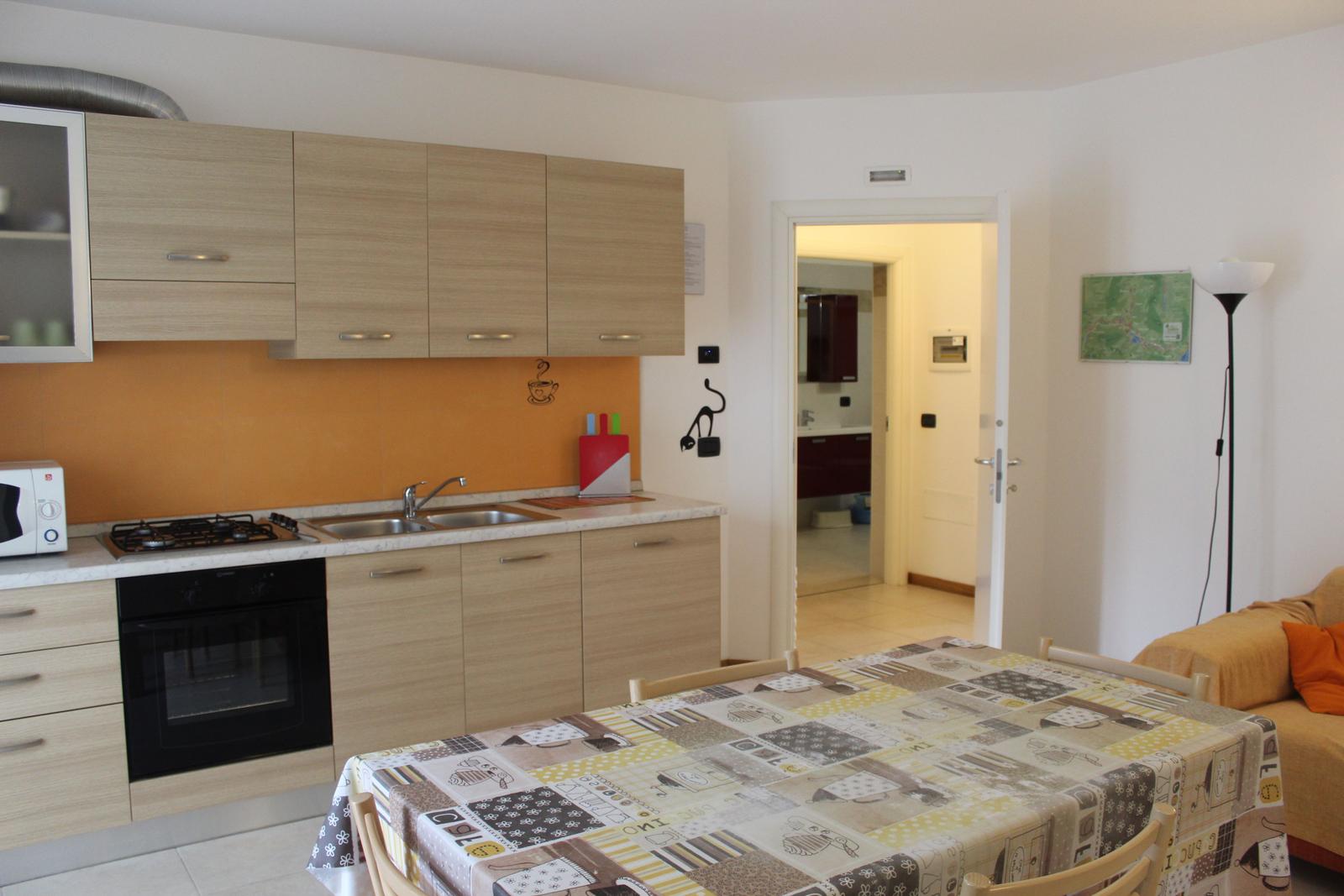 Küche mit Essbereich und Blick in das Badezimmer