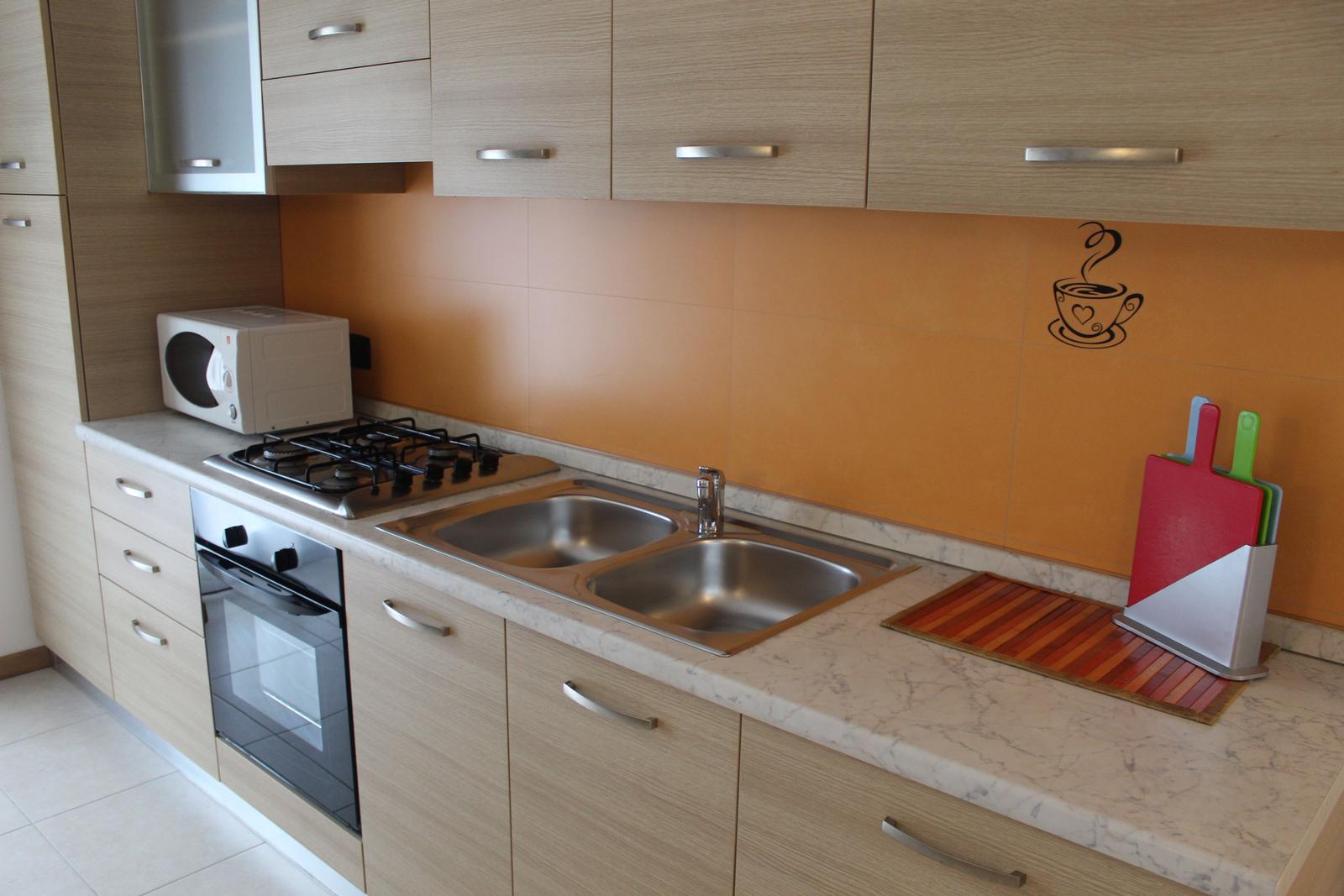 Küche mit Arbeitsplatte, Spüle, Herd und Backofen.