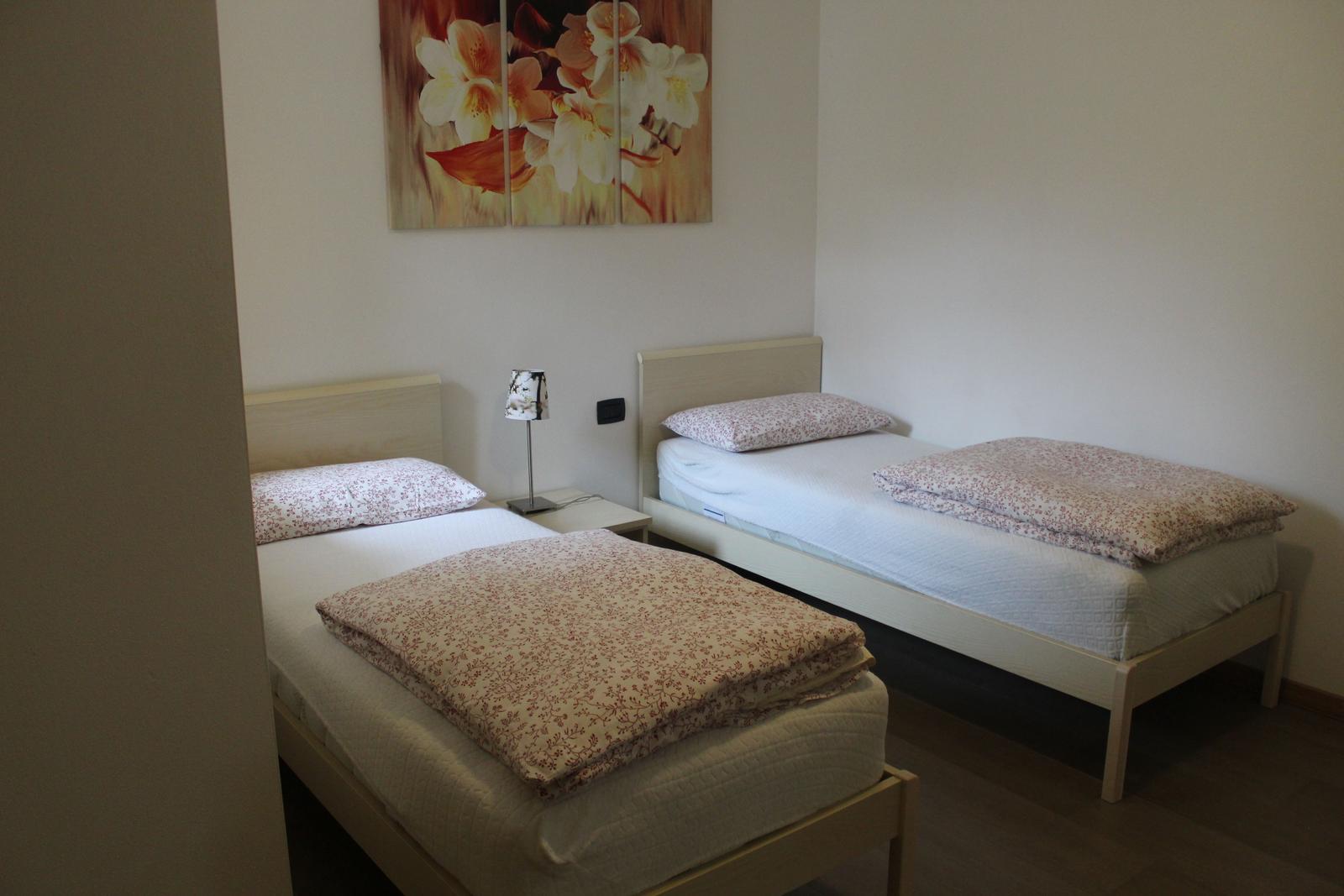 Zwei Einzelbetten mit gemusterten Bettwäsche und einer Wanddekoration.