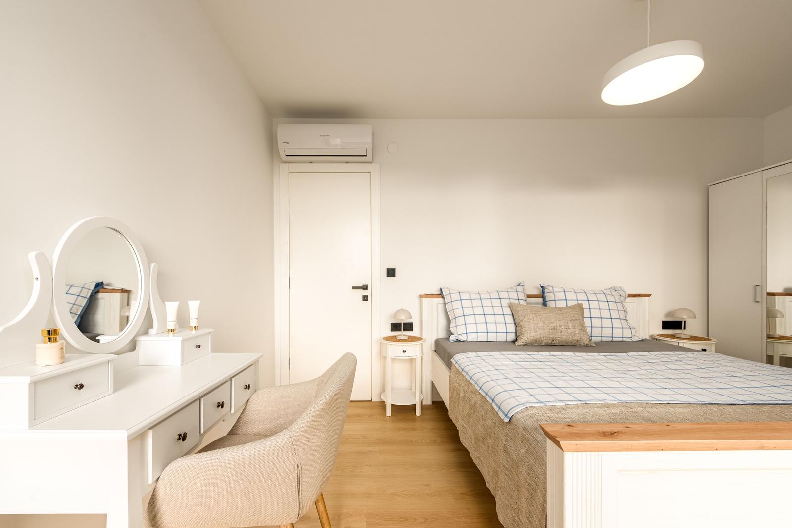 Bedroom with bed, vanity table, and wardrobe.