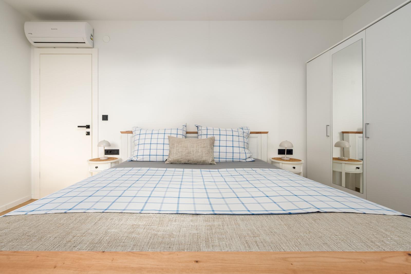 Bedroom with double bed, nightstands, and wardrobe.