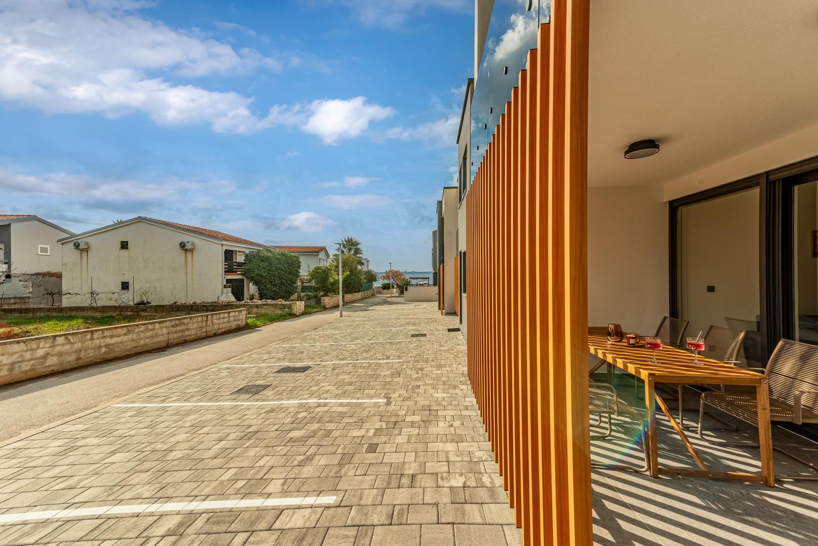 Terrace with wooden table and chairs beside a modern building.