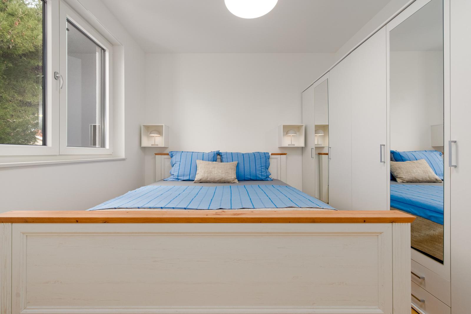 Bedroom with bed, wardrobe, and window