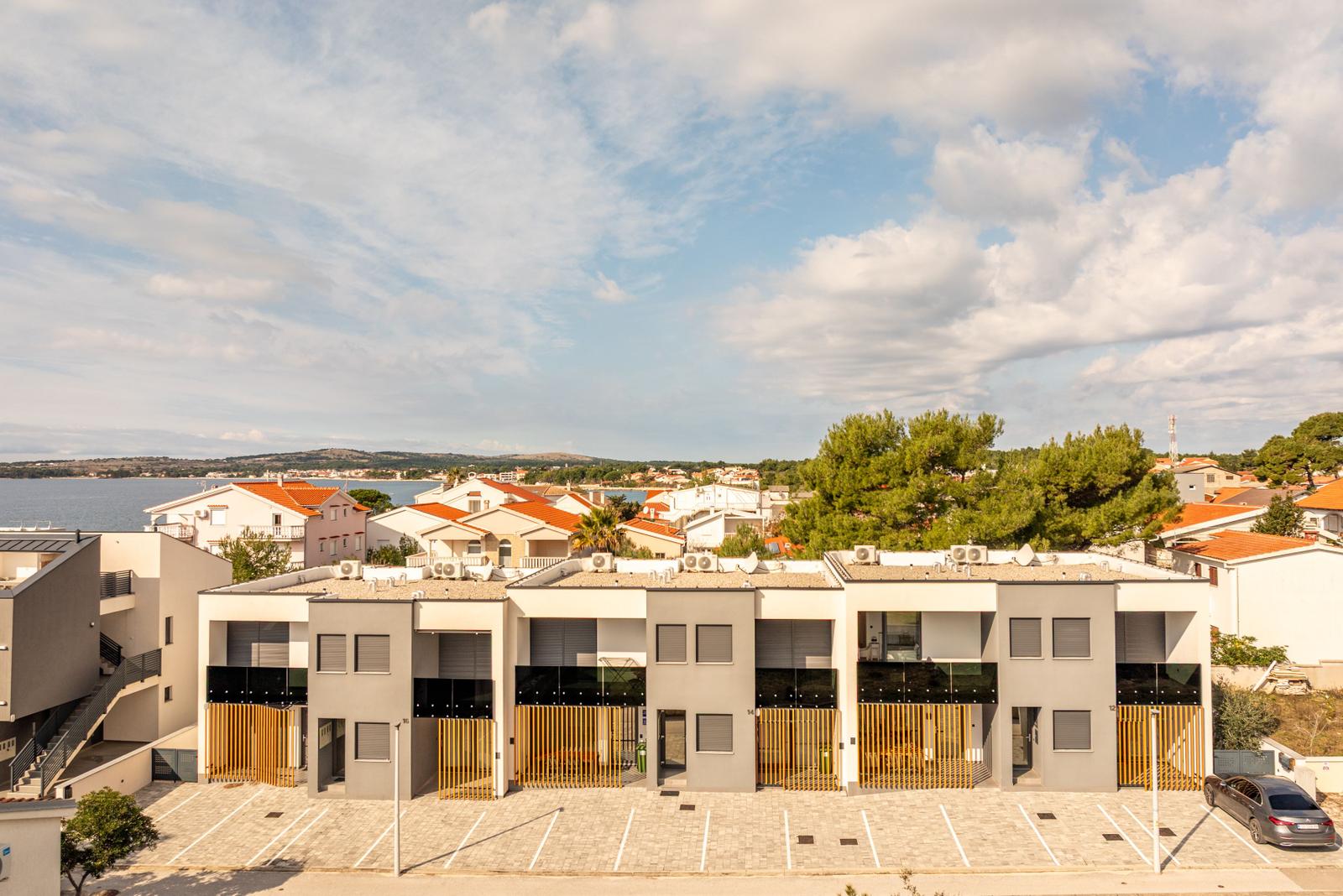 Modern vacation apartments with sea and surrounding buildings view.