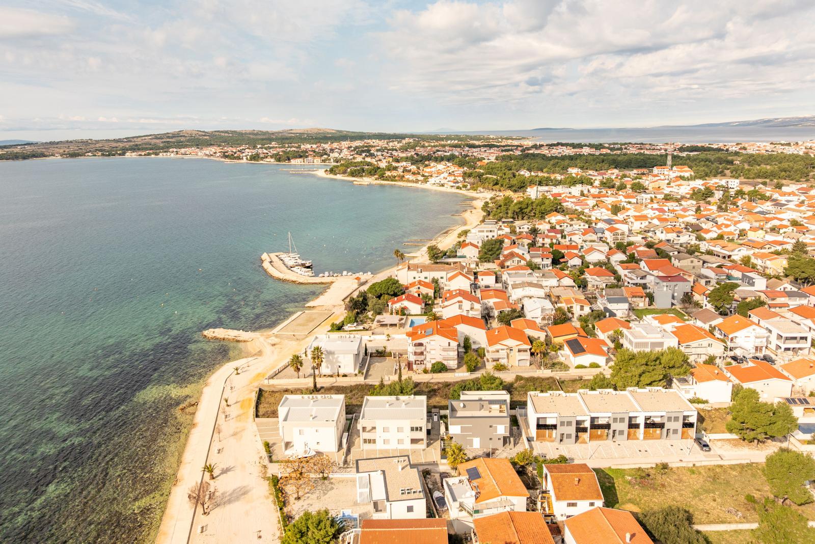 Aerial view of coastal town with houses and clear sea.