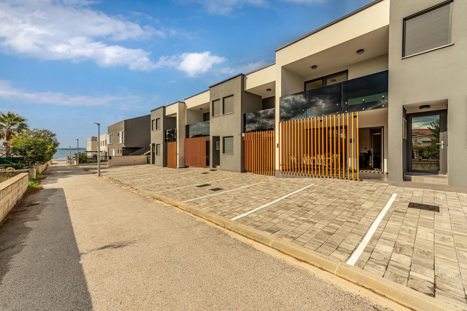 Modern vacation homes with terraces and parking spaces by the coast.