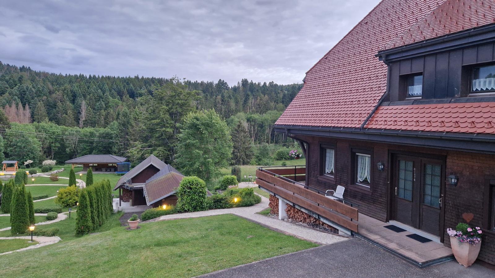 House with balcony, garden, and forest view