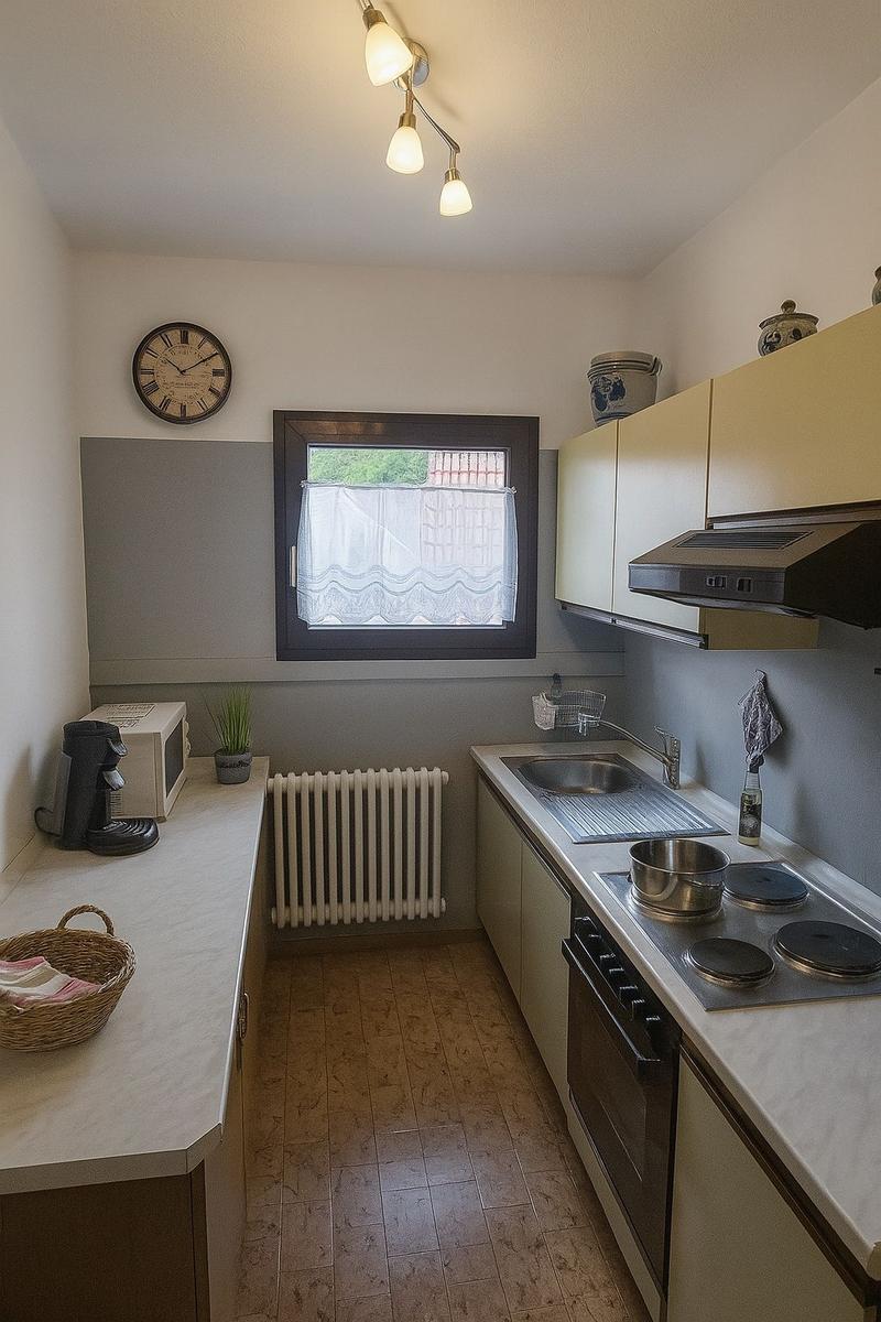 Kitchen with worktop, stove, sink, and window.