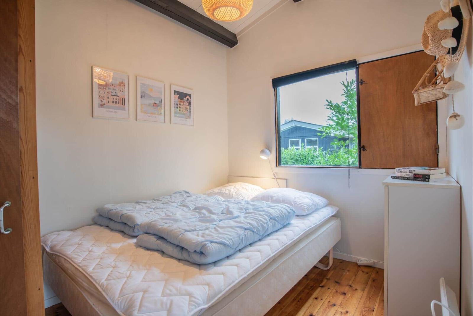 Bedroom with bed, window, and wall art.