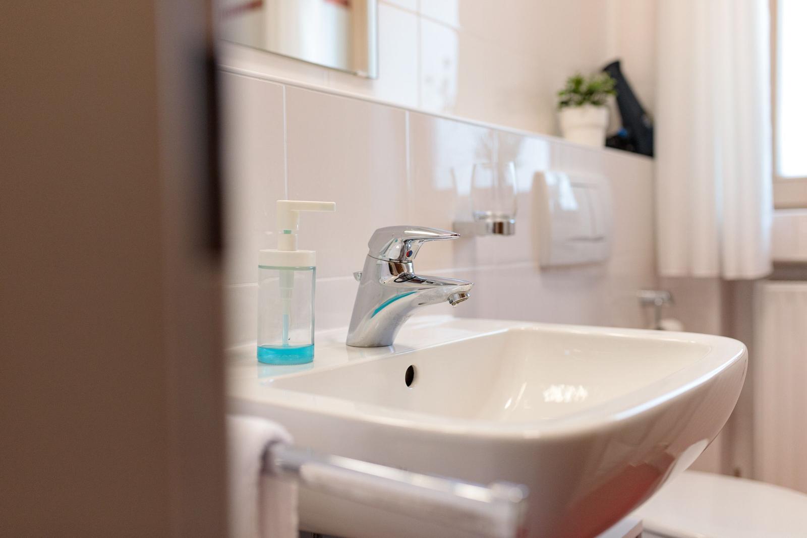 Waschbecken mit Wasserhahn und Seifenspender in Badezimmer